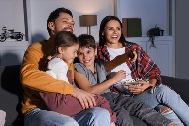 Happy family watching TV at home in evening