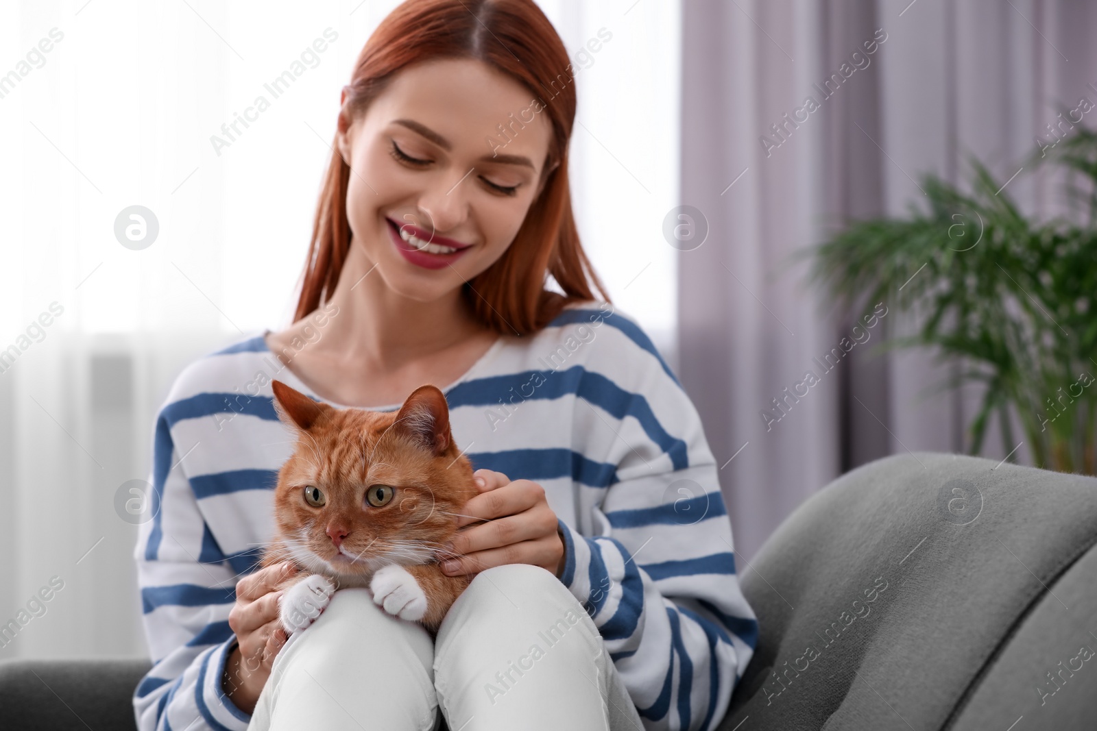 Photo of Happy woman with her cute cat at home