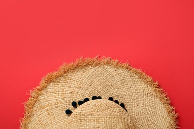 Photo of Stylish straw hat on red background, top view. Space for text