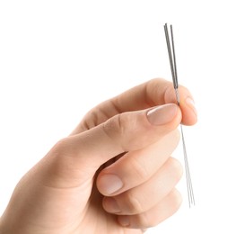 Woman holding needles for acupuncture on white background, closeup