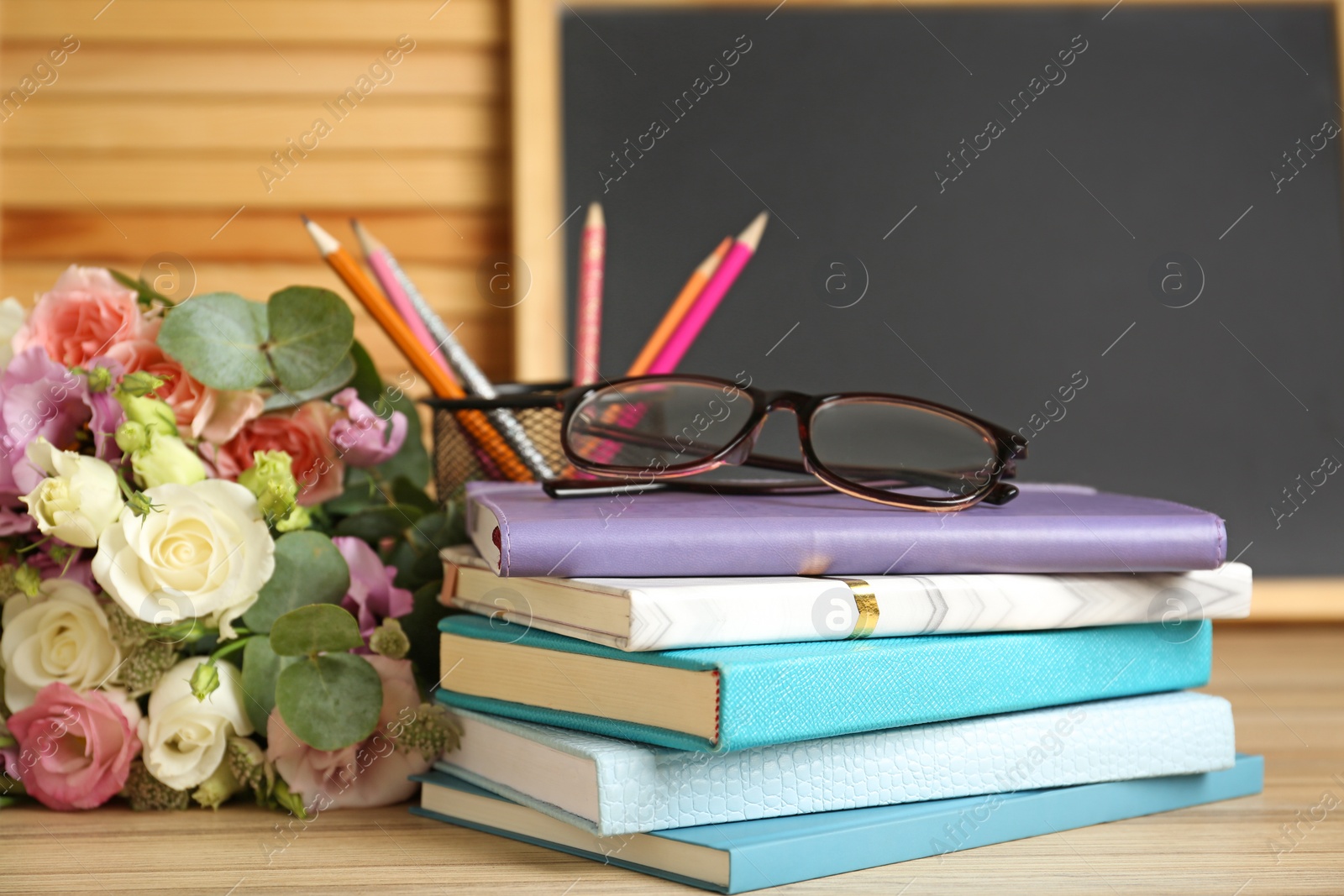 Photo of Composition with flowers and notebooks for Teacher's day on wooden table