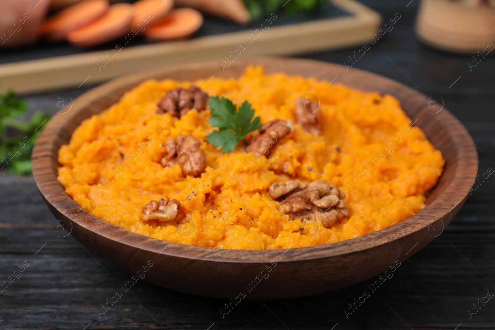 Photo of Bowl with mashed sweet potatoes on wooden table