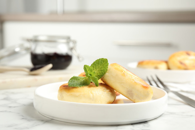 Photo of Delicious cottage cheese pancakes with mint on white marble table