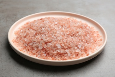 Photo of Pink himalayan salt on grey table, closeup