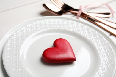 Beautiful place setting for romantic dinner on white table, closeup. Valentine's day celebration