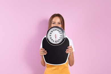 Photo of Slim woman with scale on color background. Healthy diet