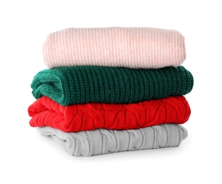 Photo of Stack of different warm sweaters isolated on white