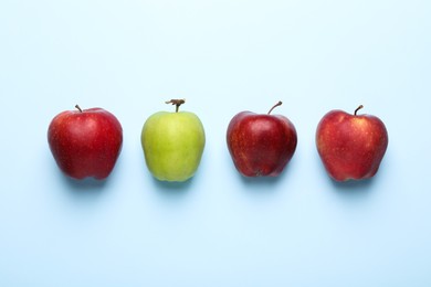 Photo of Ripe red and green apples on light blue background, flat lay