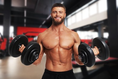 Image of Happy bodybuilder exercising with dumbbells in gym