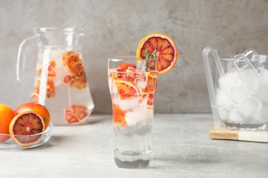 Photo of Delicious refreshing drink with sicilian orange on light grey table
