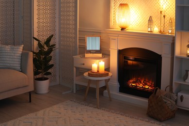 Photo of Beautiful fireplace and different decor in living room at night. Interior design