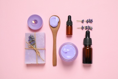 Cosmetic products and lavender flowers on pink background, flat lay