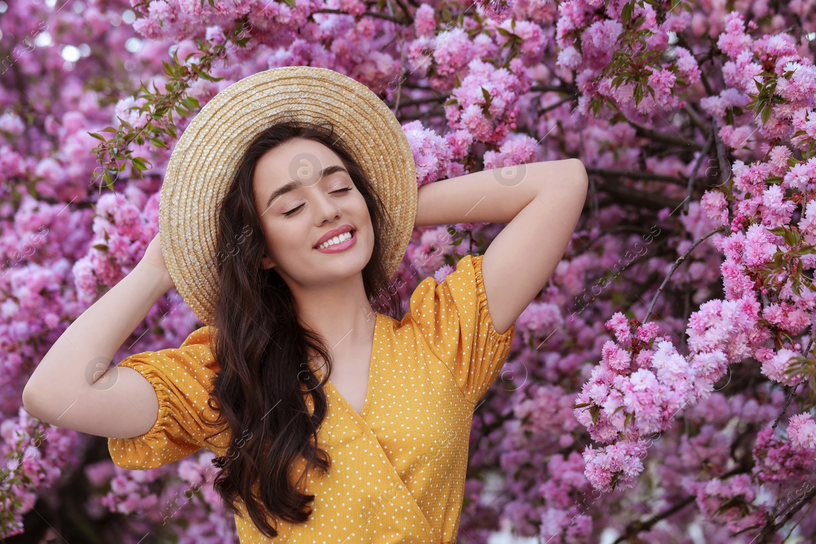 Photo of Beautiful woman near blossoming sakura tree on spring day