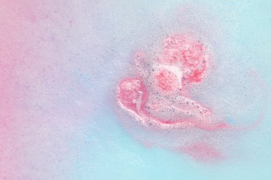 Photo of Colorful foam after dissolving bath bomb in water, closeup