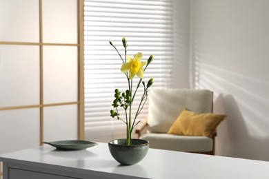 Photo of Stylish ikebana with beautiful yellow narcissus flower carrying cozy atmosphere at home