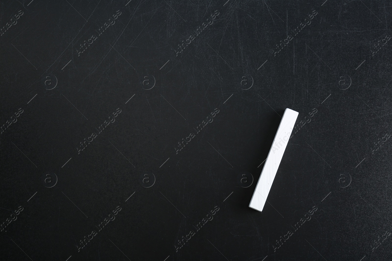 Photo of Piece of chalk on blackboard, top view