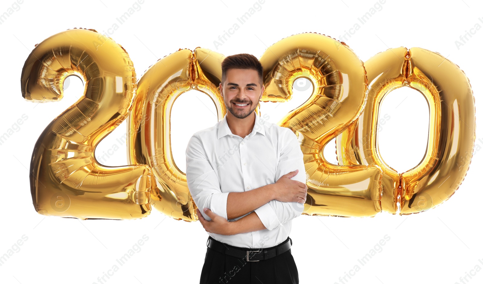 Photo of Happy young man near golden 2020 balloons on white background. New Year celebration