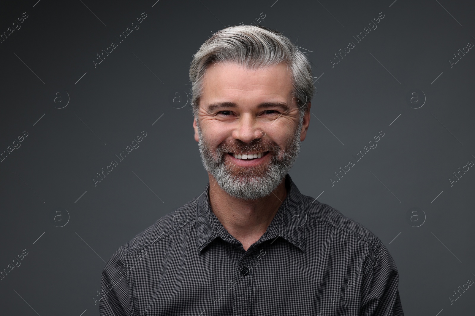 Photo of Personality concept. Portrait of happy man on dark grey background
