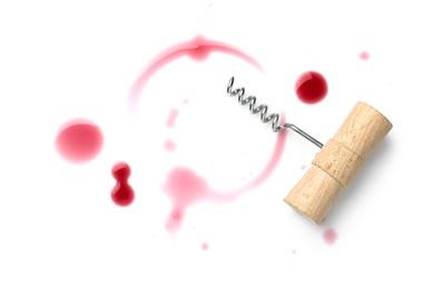 Red stain from wine glass and corkscrew on white background, top view