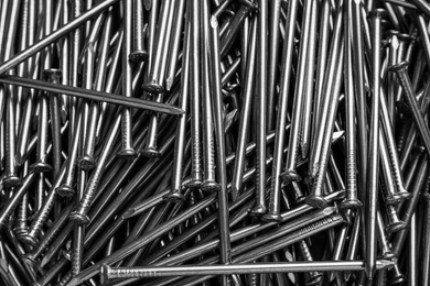 Photo of Top view of metal nails as background, closeup
