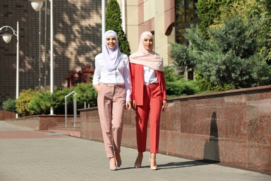 Muslim women in hijabs outdoors on sunny day