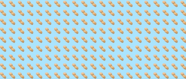 Image of Unpeeled peanuts on light blue background. Pattern, banner design