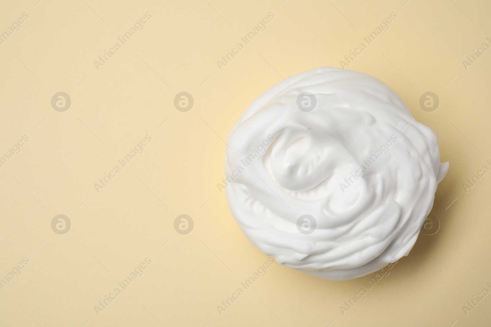 Photo of Sample of shaving foam on beige background, top view. Space for text