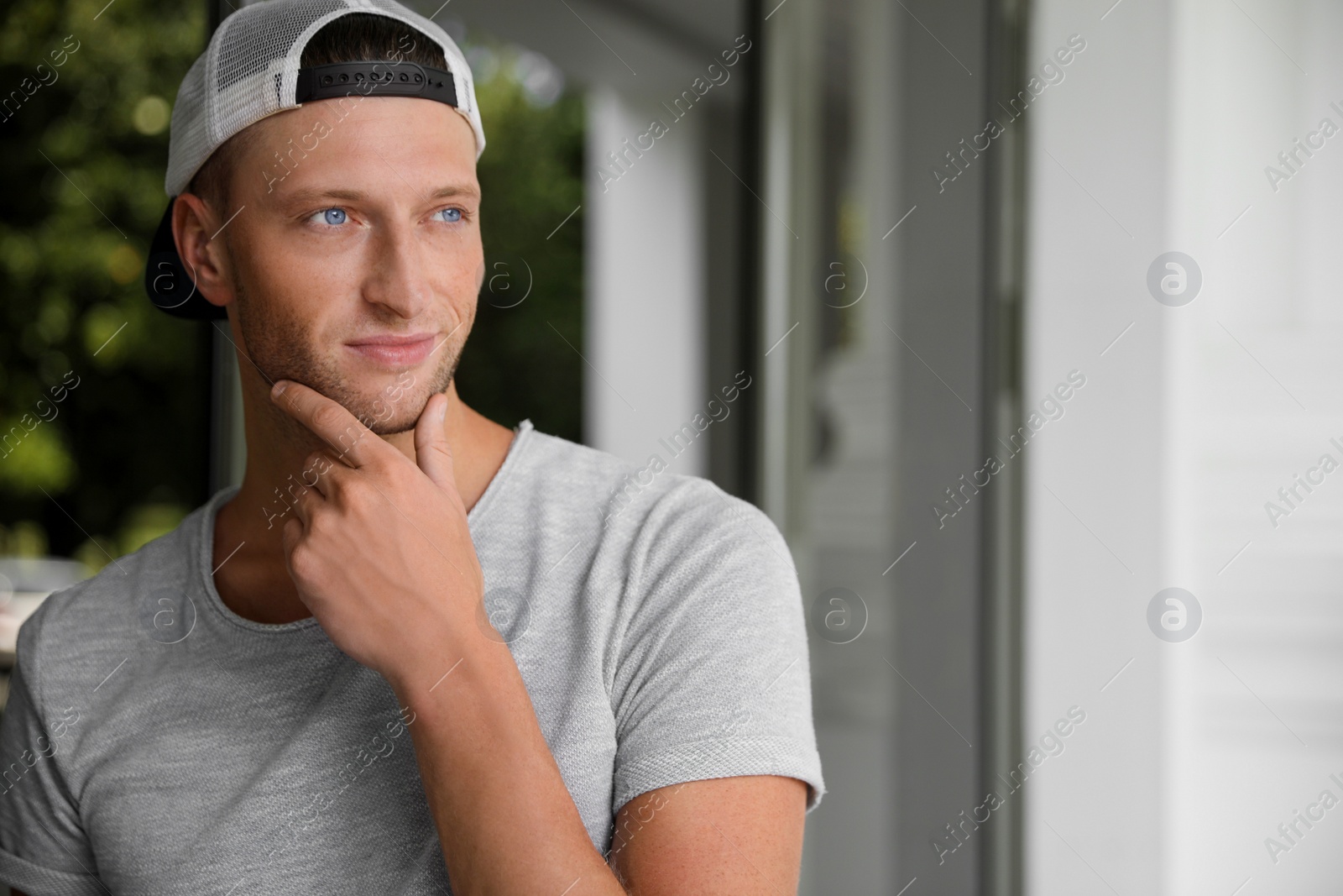 Photo of Portrait of handsome young man in stylish cap outdoors, space for text