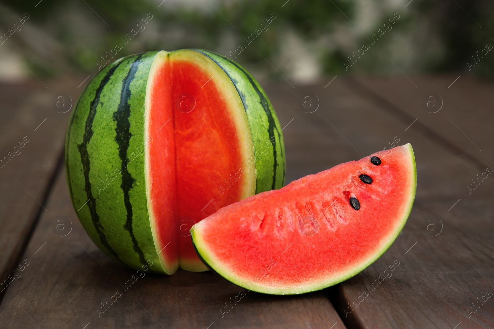 Photo of Delicious cut ripe watermelon on wooden table