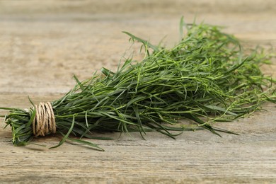 Bunch of fresh tarragon on wooden table, closeup