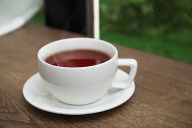 Cup of hot tea on wooden table