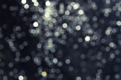 Photo of Silver glitter on dark background. Bokeh effect