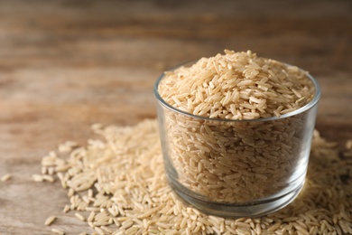 Photo of Brown rice in glass on table. Space for text