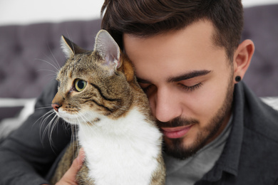 Photo of Happy man with cat at home. Friendly pet