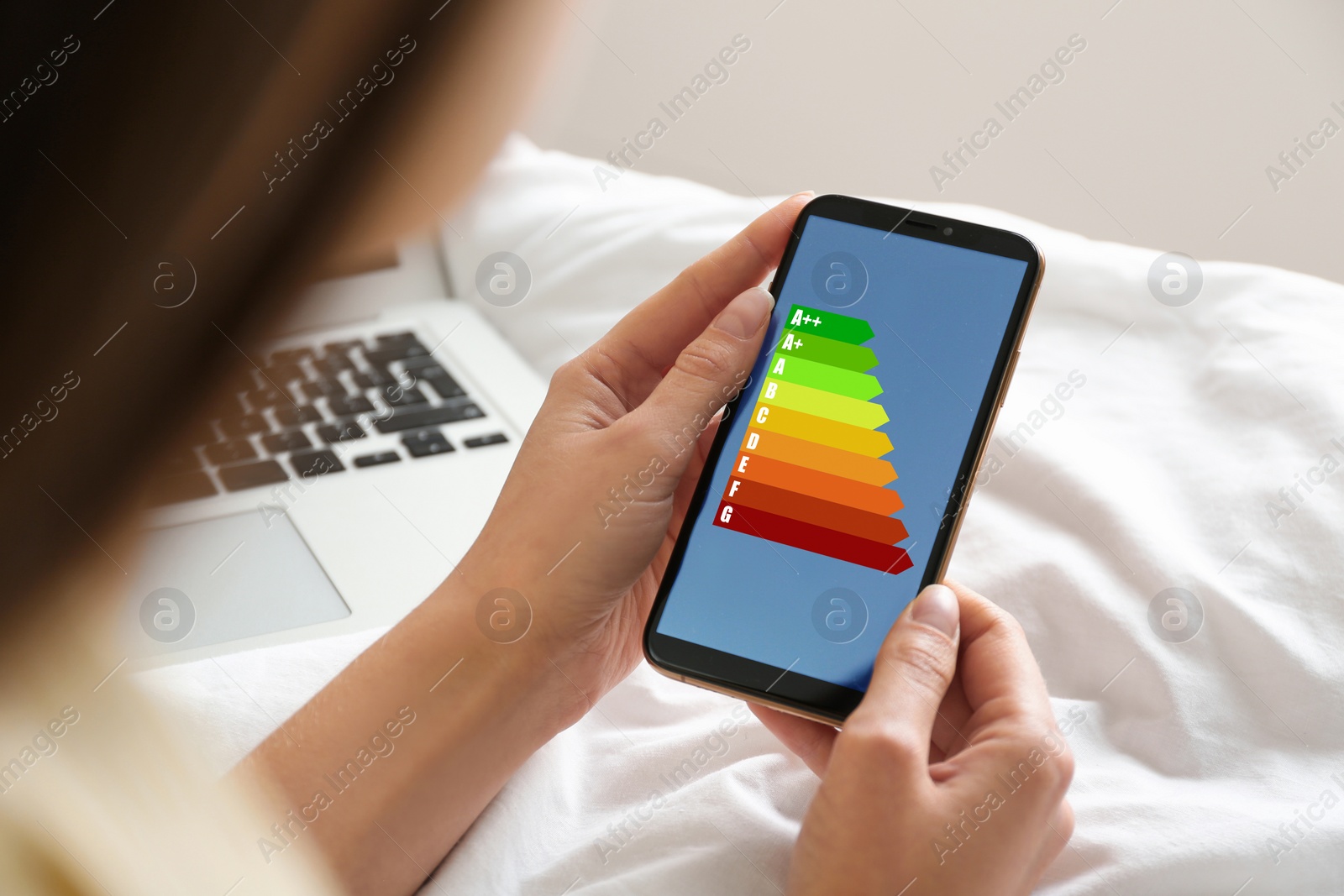 Image of Energy efficiency. Woman using smartphone with colorful rating on display, closeup