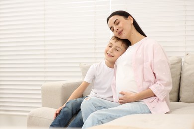 Photo of Pregnant woman with her son at home, space for text