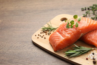 Photo of Fresh raw salmon and ingredients for marinade on wooden table, space for text