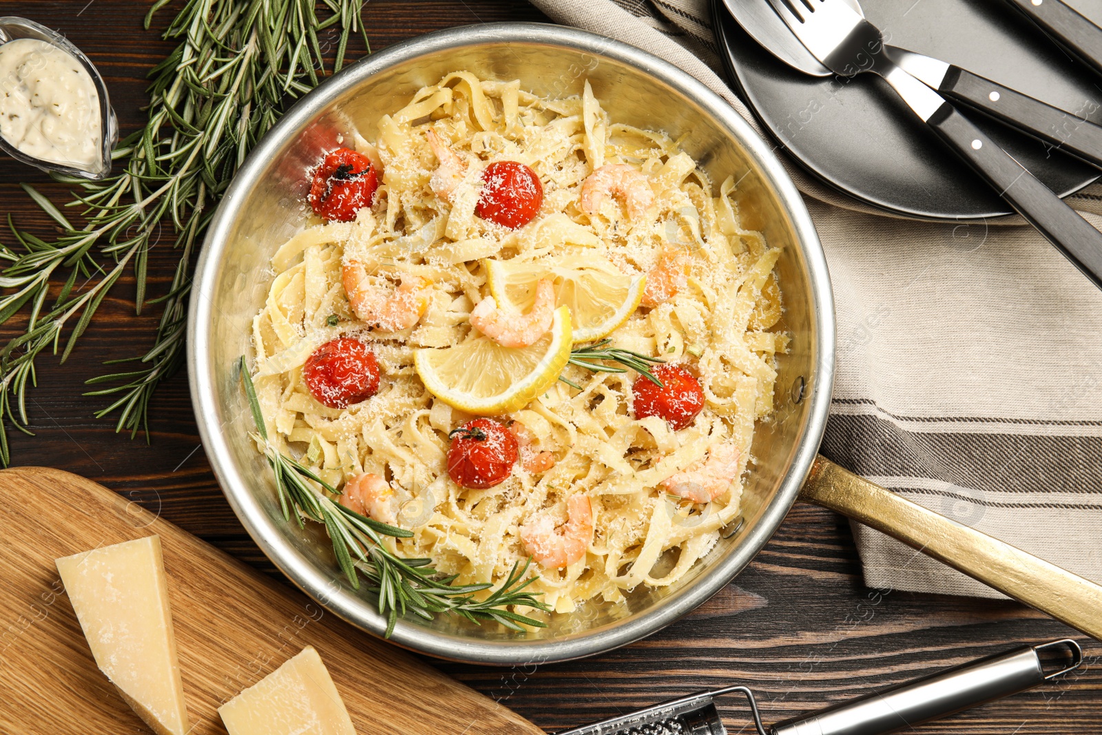 Photo of Delicious pasta with shrimps served on wooden table, flat lay