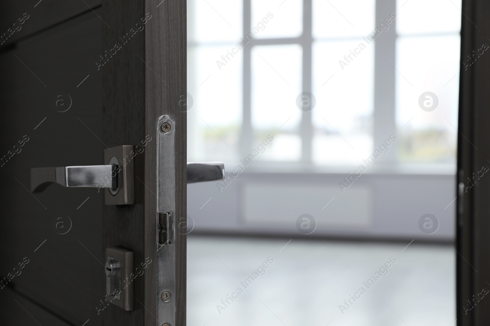 Photo of Wooden door open into empty office room, closeup. Space for text