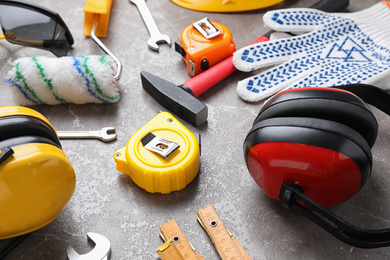 Many different construction tools on grey marble table