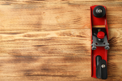 Modern jack plane and space for text on wooden background, top view. Carpenter's tool