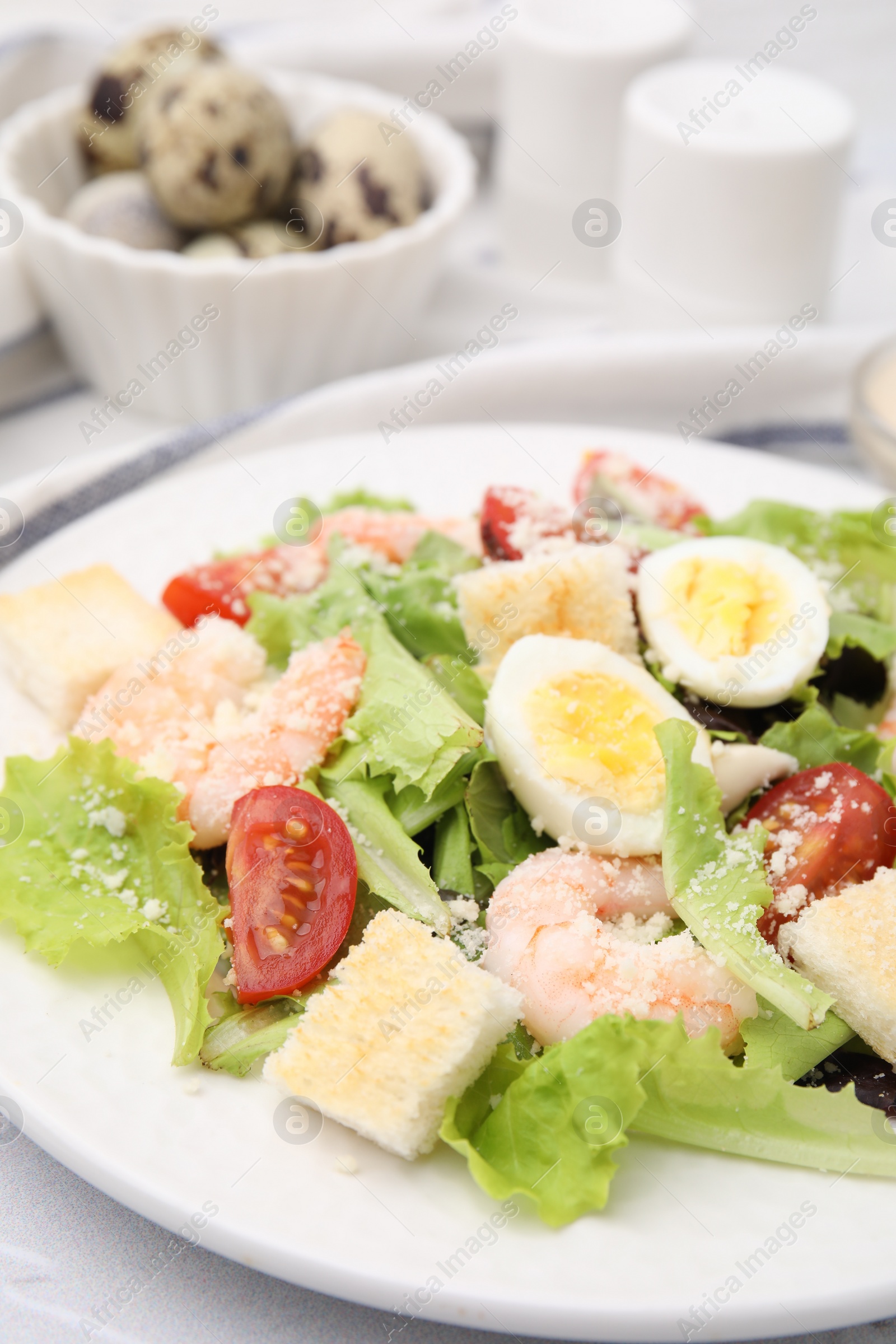 Photo of Delicious Caesar salad with shrimps on table