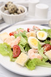 Photo of Delicious Caesar salad with shrimps on table