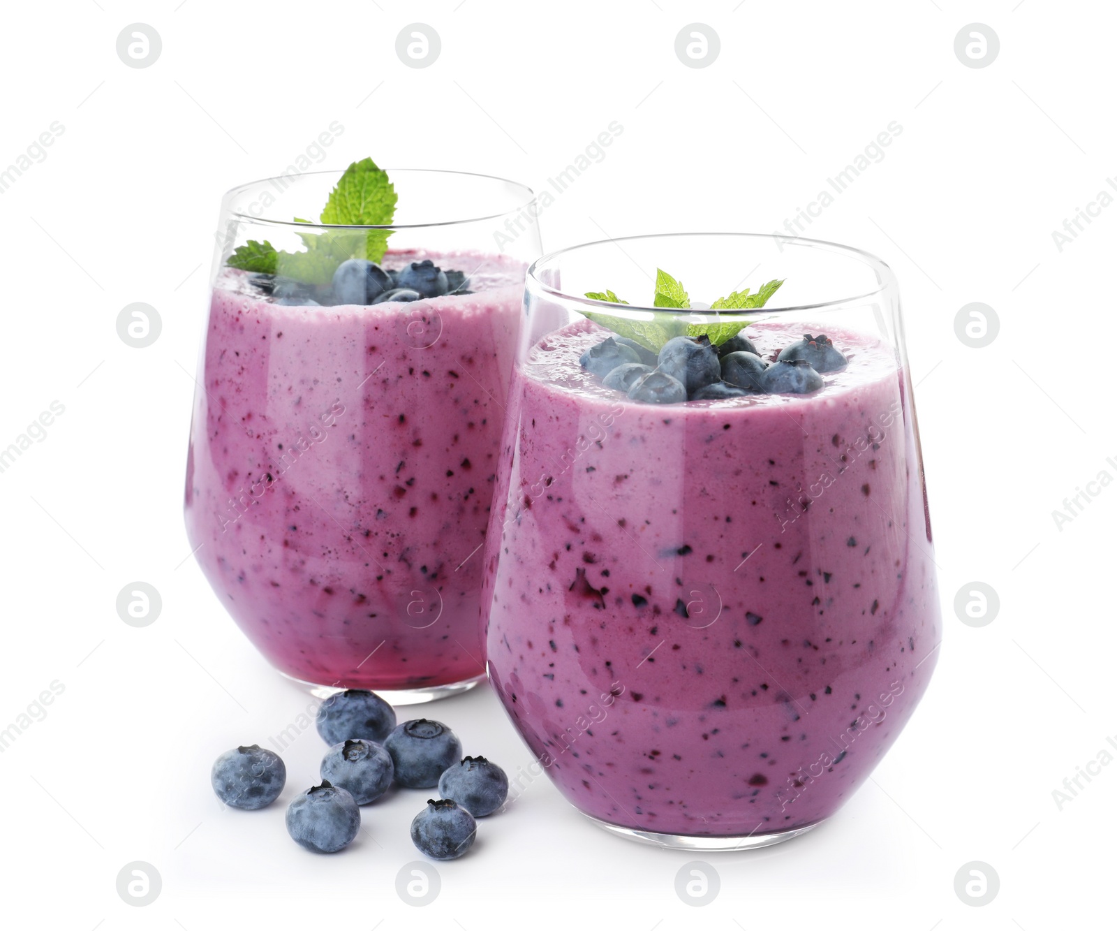 Photo of Glasses of tasty blueberry smoothie with mint on white background