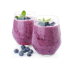 Photo of Glasses of tasty blueberry smoothie with mint on white background