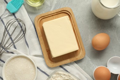 Photo of Flat lay composition with fresh butter and other products on grey marble table