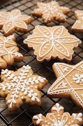 Photo of Tasty Christmas cookies on cooling rack, closeup