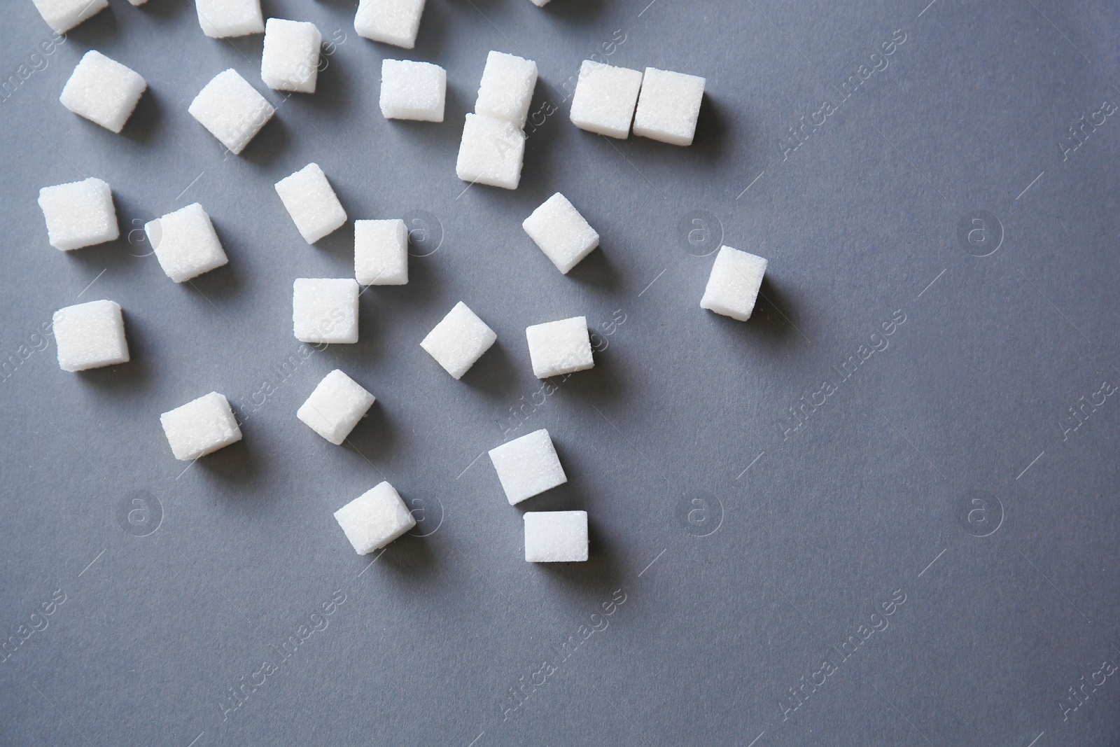 Photo of Refined sugar cubes on grey background, top view