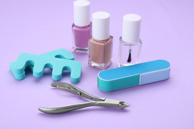 Photo of Set of pedicure tools on violet background