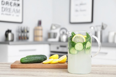 Photo of Jug with lemonade and blurred view of kitchen interior on background